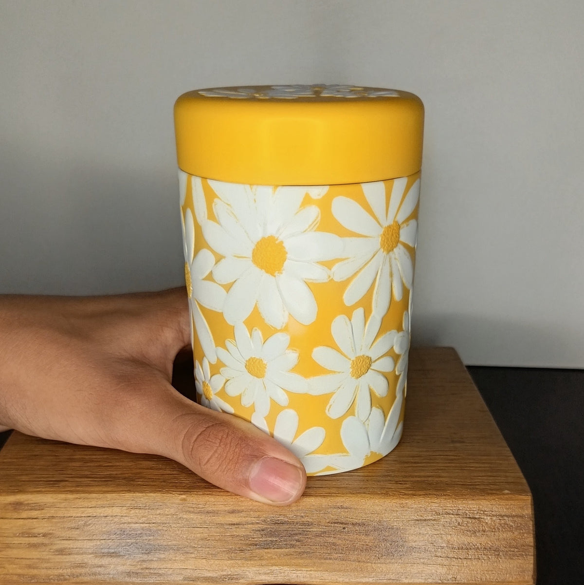 Boîte à thé en métal Daisy jaune 125 g tenue en main, taille réelle — Teavora