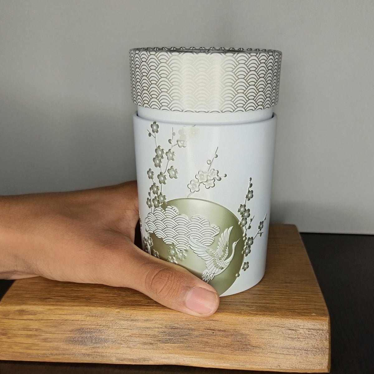 Boîte à thé en métal Komorebi blanche 150 g tenue en main, taille réelle — Teavora