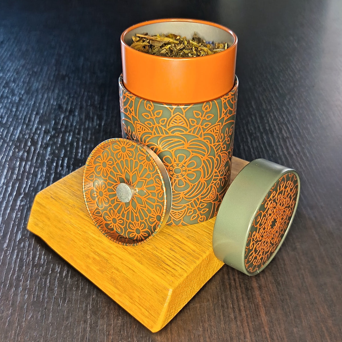 Boîte à thé Mandala marron ouverte, couvercle retiré et feuilles de thé en vrac — Teavora
