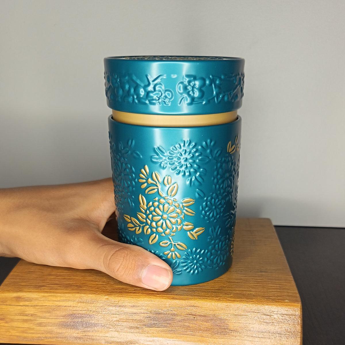Boîte à thé en métal Yumiko bleue 150 g tenue en main, taille réelle — Teavora